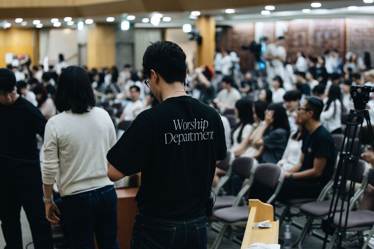 Home Crowd attending a church service with worship team preparing in the foreground.