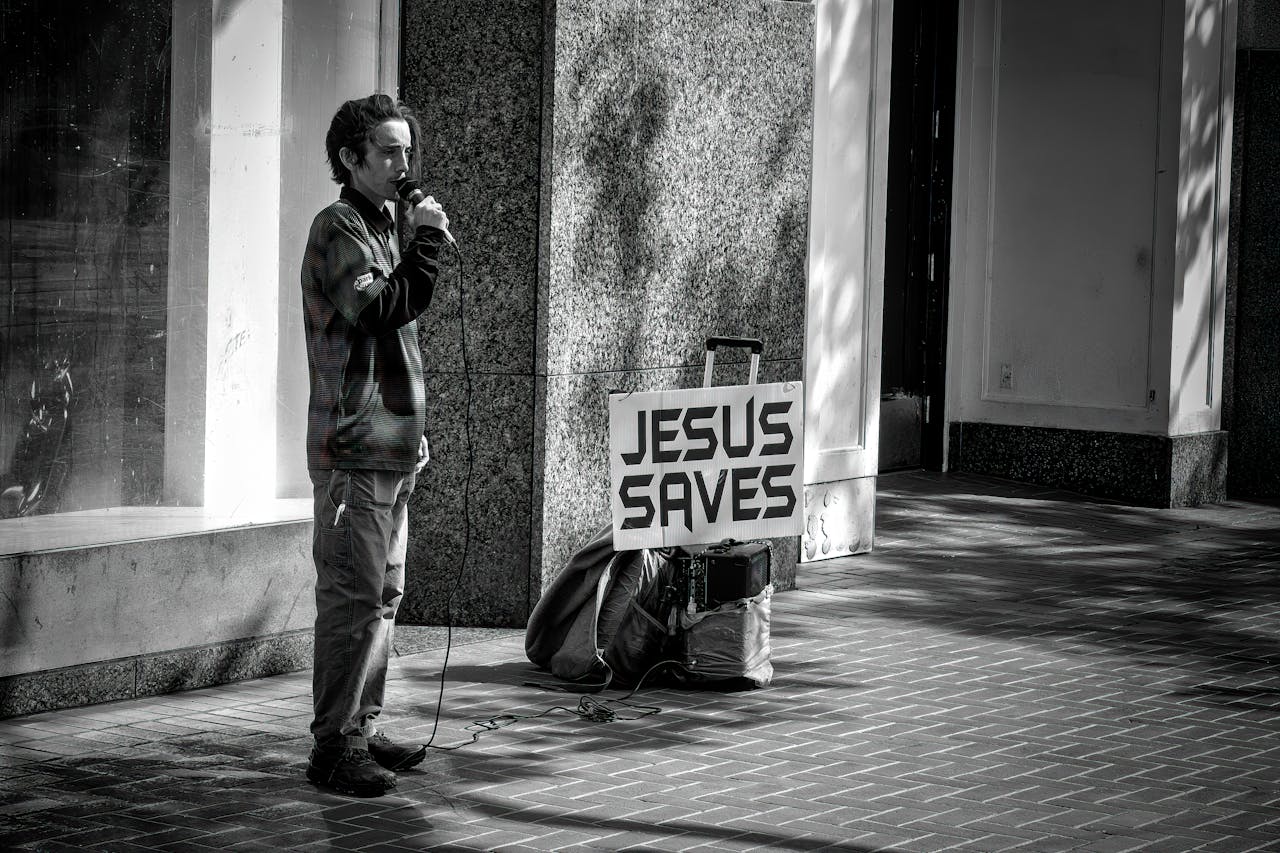 Man preaching with 'Jesus Saves' sign on San Francisco street corner.