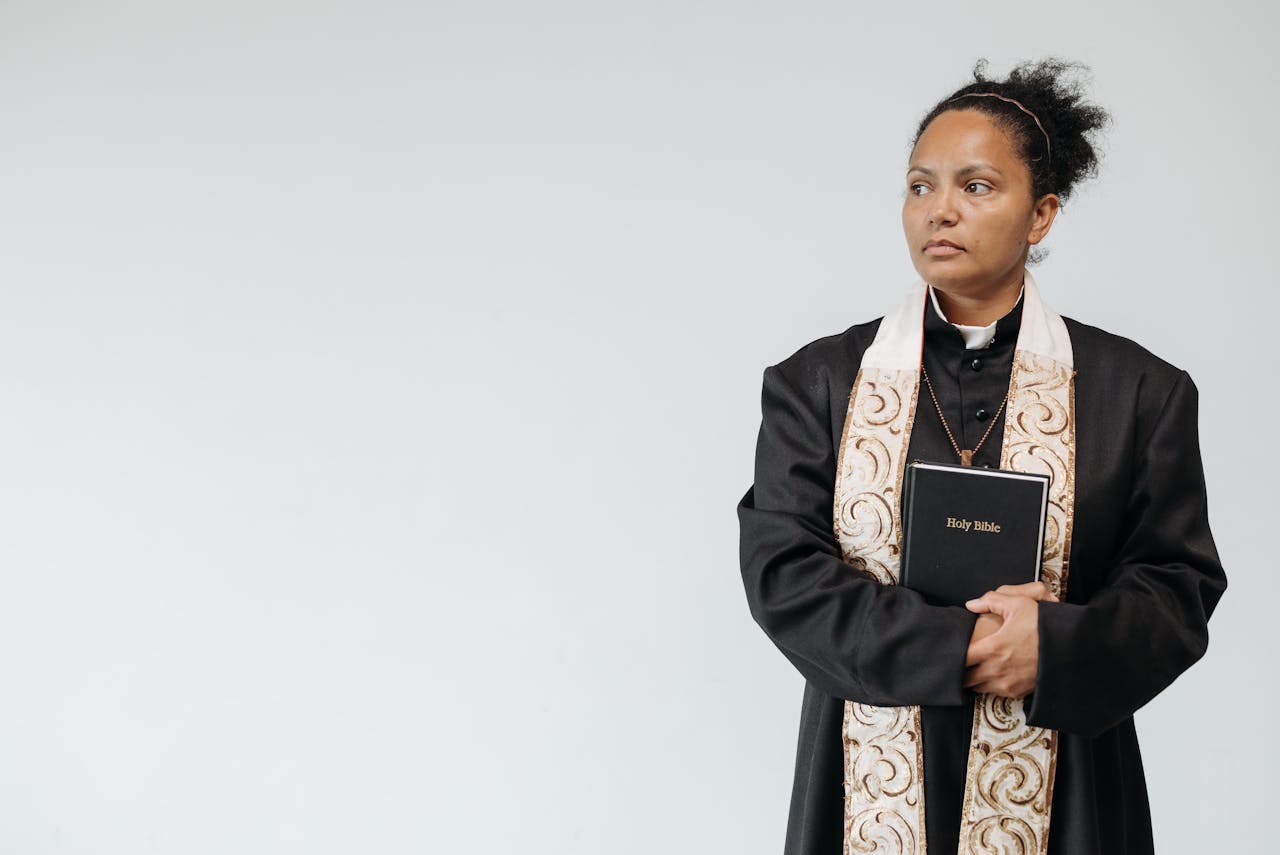 Crafting Captivating Headlines: Your awesome post title goes here A female priest in religious attire holding a Holy Bible, symbolizing faith and spirituality.